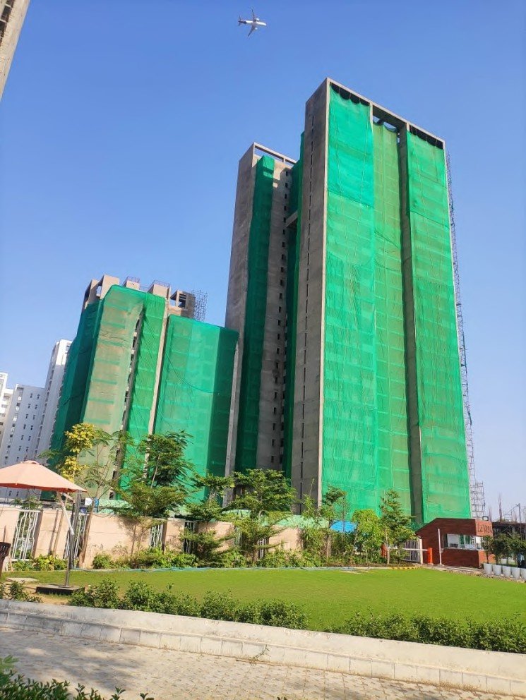 Green safety netting wrapped around a high-rise residential tower